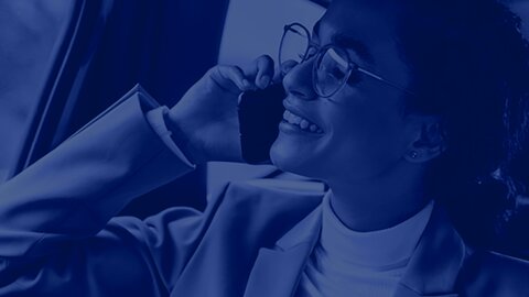A woman in a suit and glasses can be seen in the crop, talking on the phone and gazing contentedly into the distance. A blue filter is placed over the image. | © wob AG