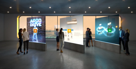 The image shows a section of the Digital Experience Platform for ebm-papst. A virtual showroom can be seen. At the centre of the showroom are three interactive holograms that provide users of the Experience Platform with information on ebm-papst's products and services and are also clickable. The latter is characterised by small clickable crosses located on the holograms. To round off the feeling of a virtual exhibition, virtual people stand around the holograms and take a closer look at them.