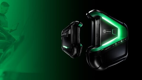 The picture is predominantly green with black elements. A car door can be seen on the left-hand side. To the right, the mega macs x from Hella Gutmann hovers in the side view. | © wob AG